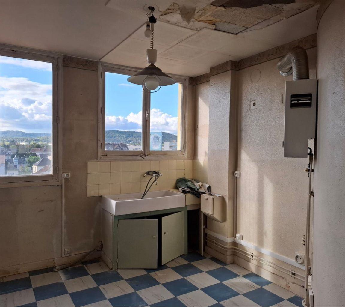 Cuisine avant travaux : carrelage à damier, évier ancien et murs à nu