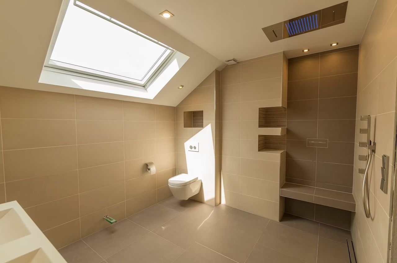 Tiled bathroom with a walk-in shower under a skylight