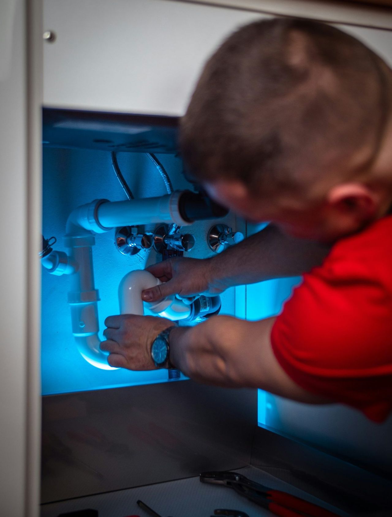 Plumber installing a trap under a washbasin