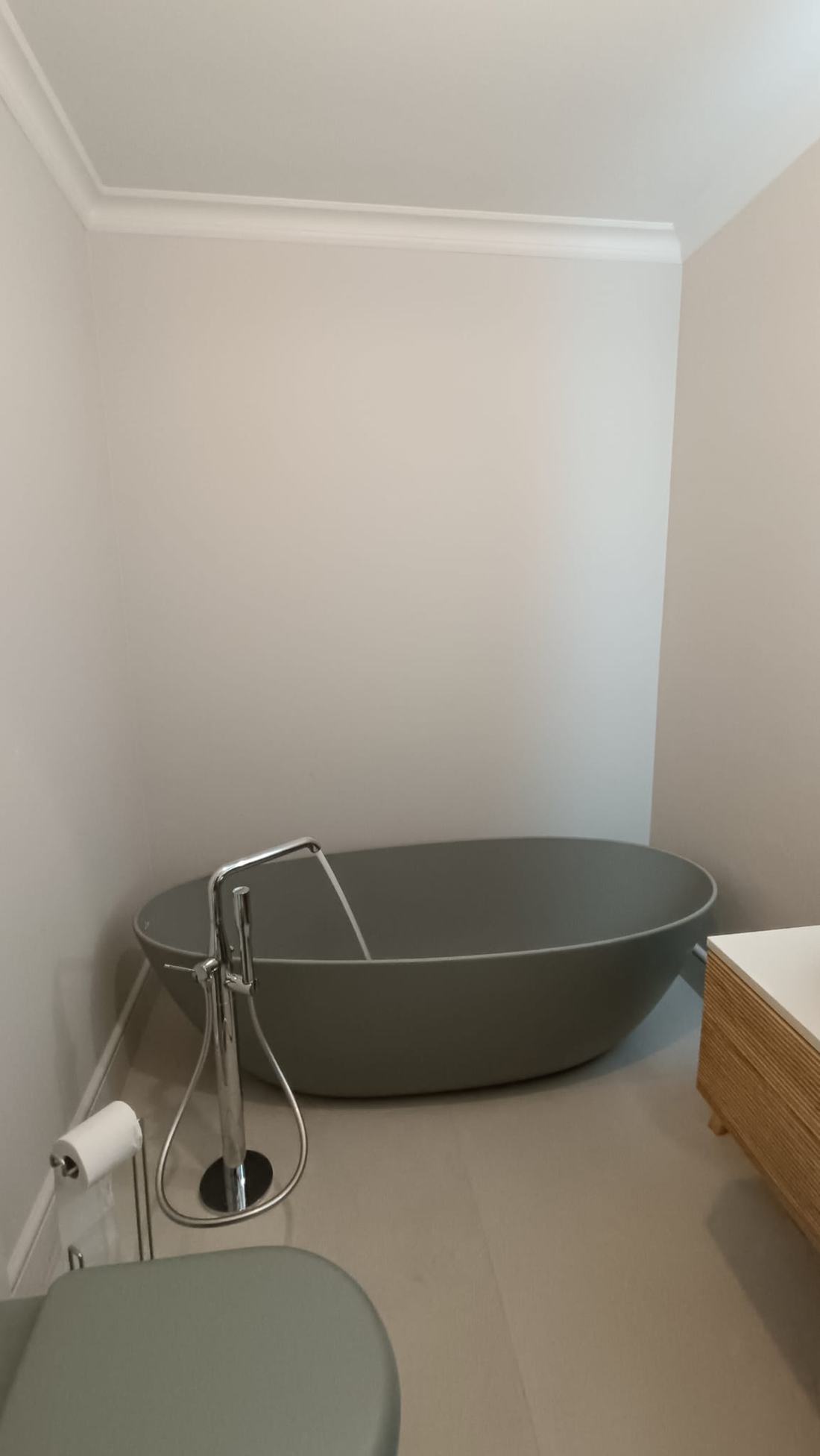 Salle de bain avec baignoire îlot verte et WC suspendu assorti