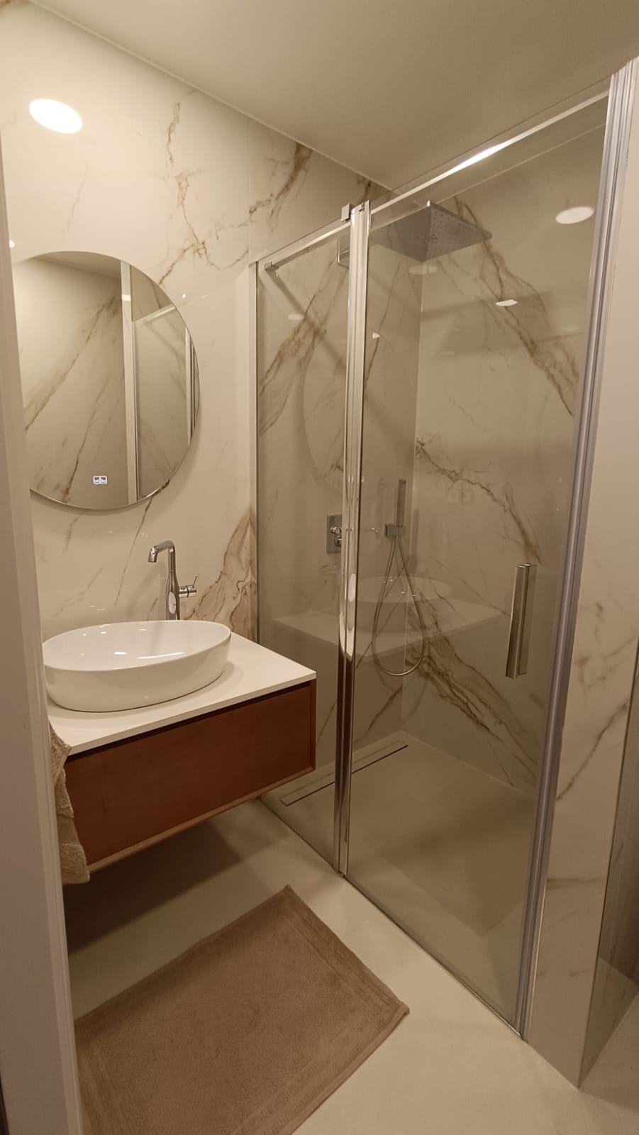 Salle d'eau en grandes dalles effet marbre avec douche vitrée et vasque à poser