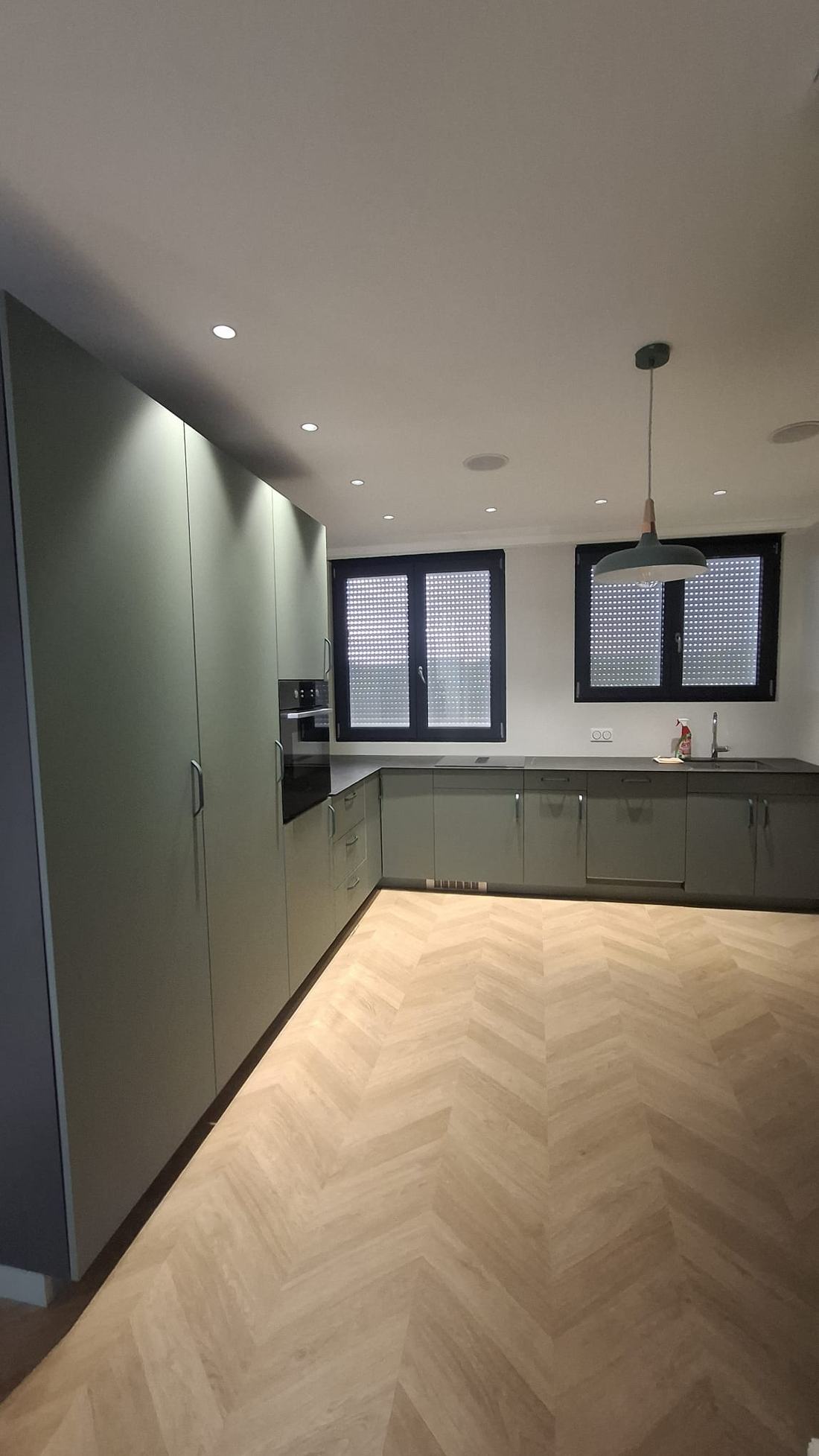 Cuisine verte en L avec parquet à chevrons