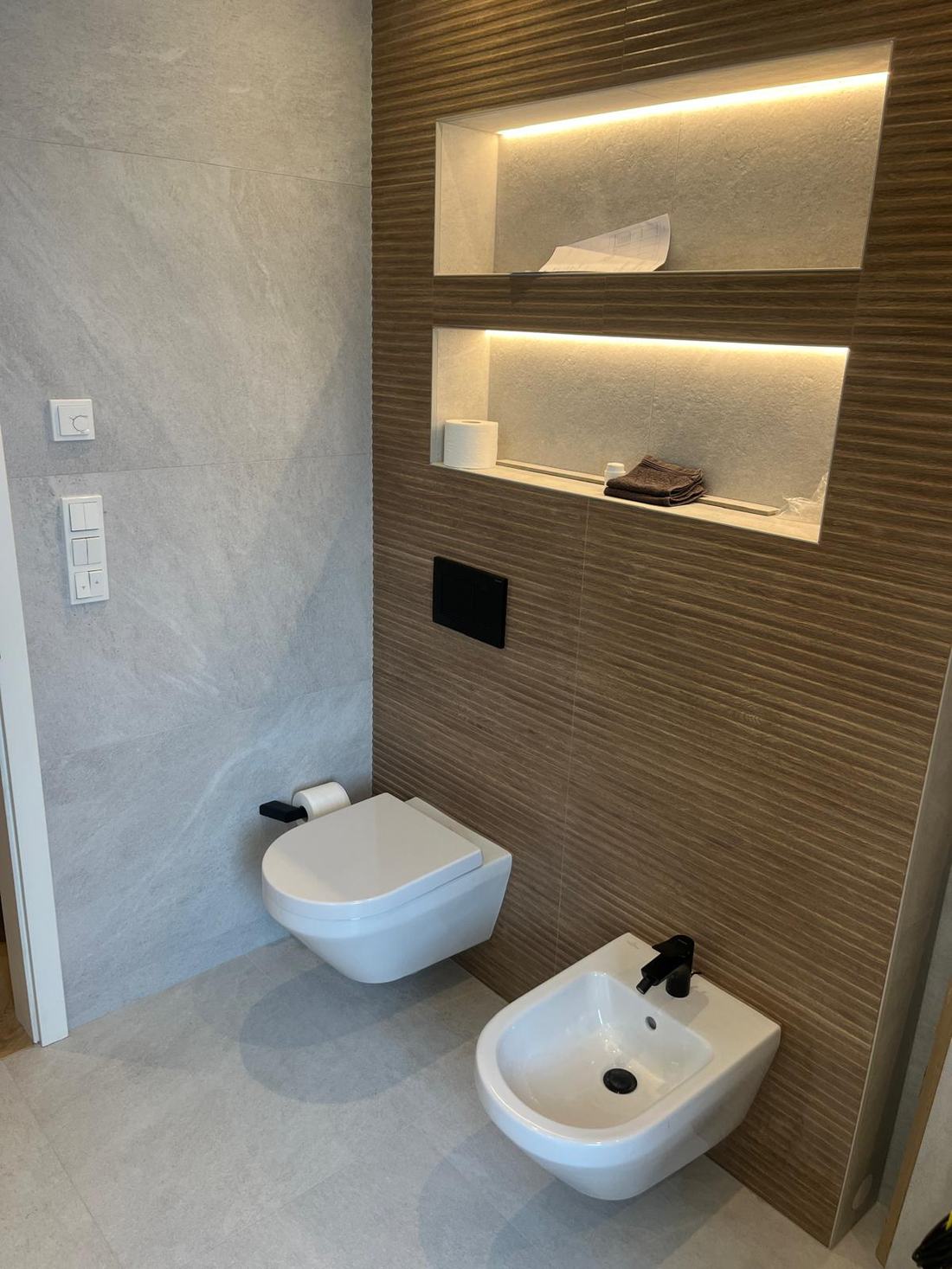WC et bidet suspendus, niches éclairées en LED et mur en relief effet bois