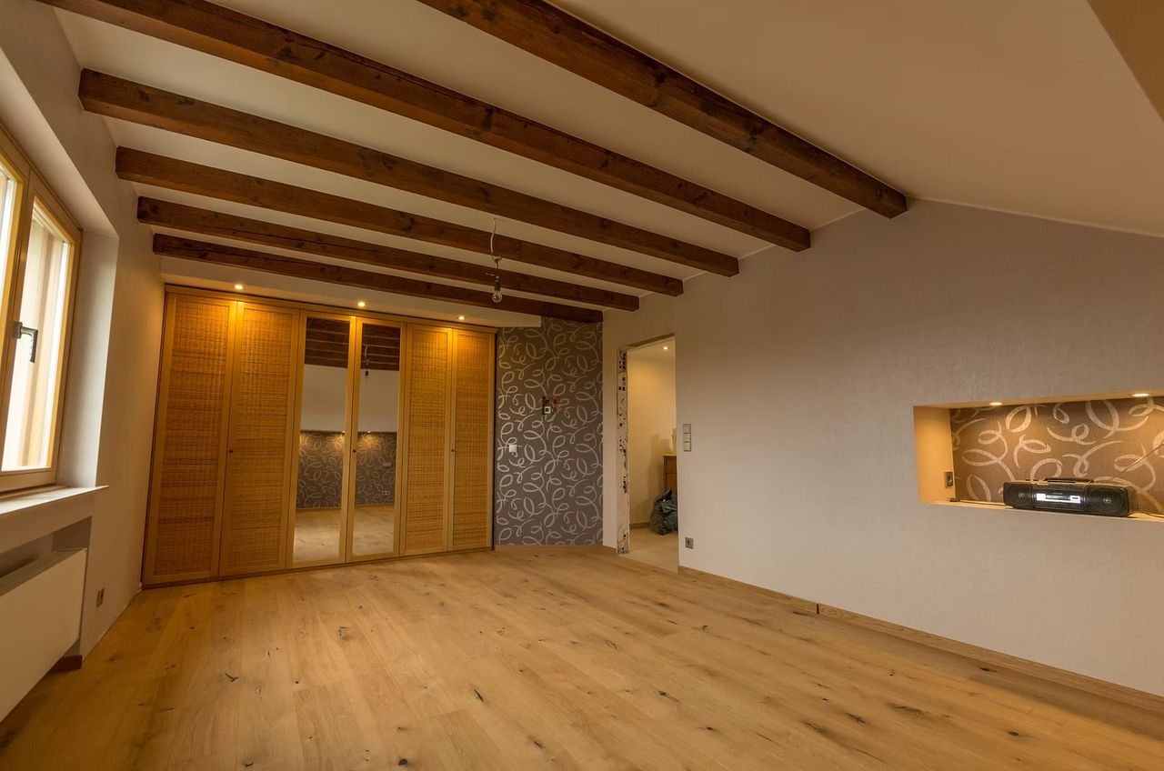 Renovated bedroom with exposed beams, oak parquet and built-in wardrobe